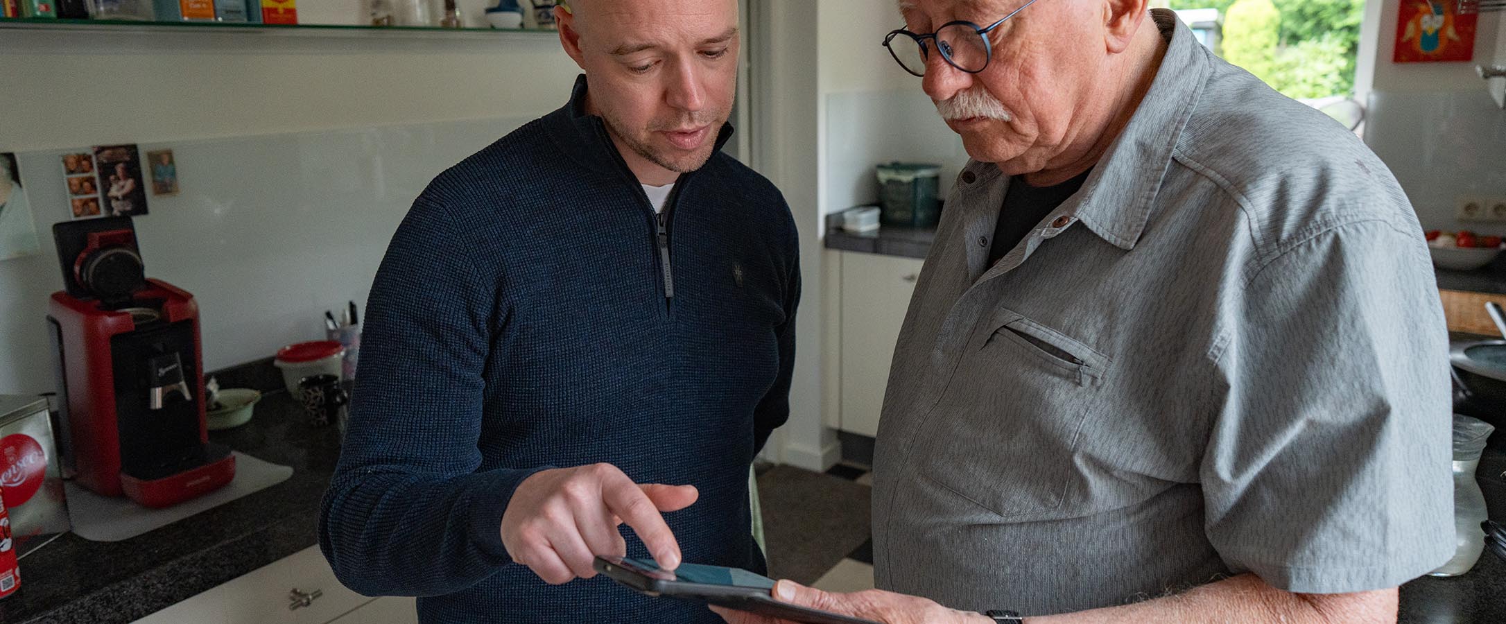 Marcel legt iets uit op een tablet bij een klant