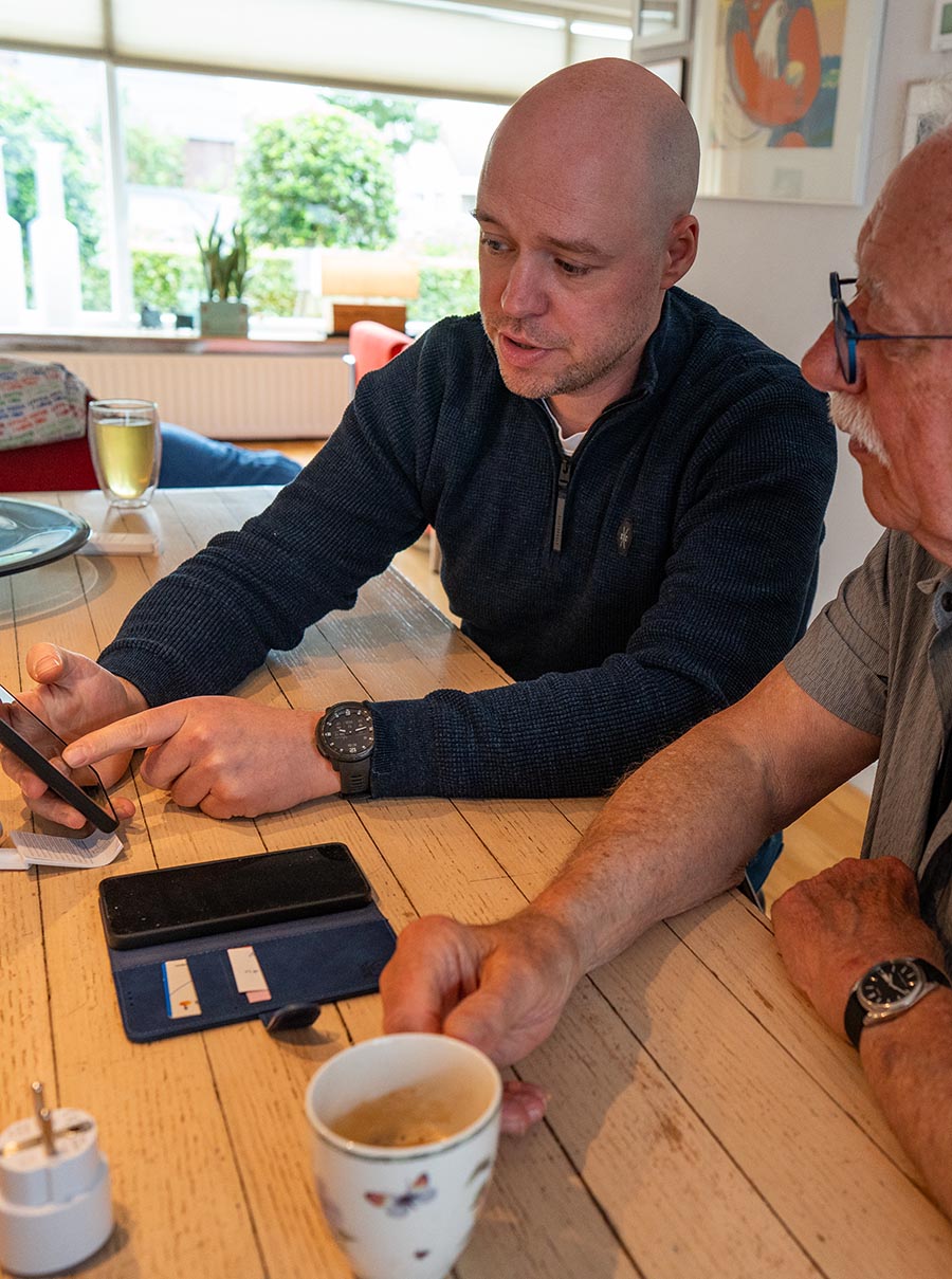 Marcel legt iets uit op een tablet bij een klant